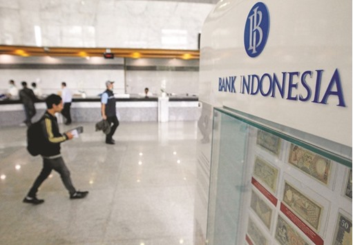 A man walks past teller counters inside Indonesiau2019s central bank in Jakarta. Bank Indonesia yesterday reduced the interest rate by 25 basis points to 4.75% despite many economists having forecast there would be no change.
