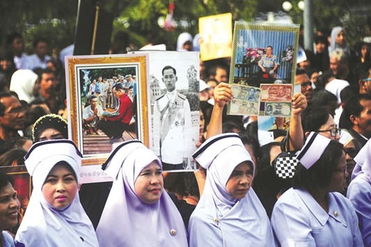 People hold pictures of the late Thai King Bhumibol Adulyadej during a gathering at Narathiwat City Hall in the southern province of Narathiwat.