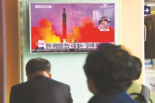 South Koreans watch a television news report showing file footage of North Koreau2019s missile launch at a railway station in Seoul yesterday.