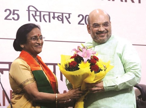 Rita Bahuguna Joshi presents a bouquet to BJP chief Amit Shah after joining the party in New Delhi yesterday.