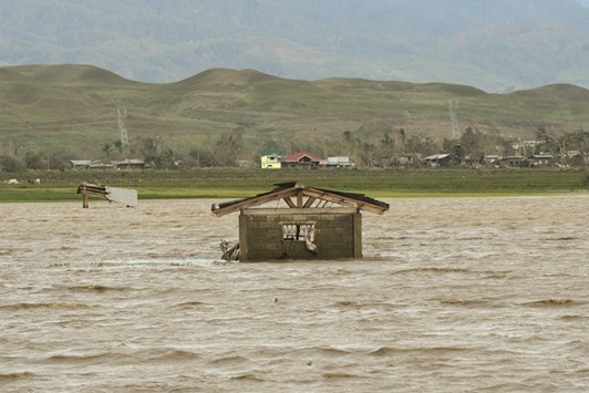 A house stands in a rice field flooded by rain brought by super typhoon Haima in Tumauini town, Isabela province.