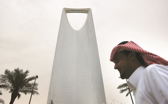 A man walks past the Kingdom Centre Tower in Riyadh. Saudi Arabiau2019s record debut international bond sale is shifting the ground across Middle East debt markets, fuelling price gains and stoking speculation of more borrowers to come.