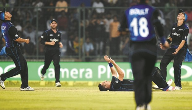 New Zealandu2019s Tim Southee (on the ground) celebrates the wicket of Indian captain Mahendra Singh Dhoni with teammates during the second ODI at the Ferozshah Kotla ground in New Delhi yesterday. (AFP)