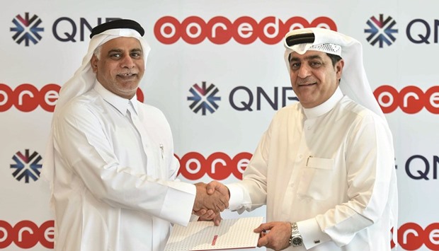 Al-Kubaisi and al-Neama shake hands after signing the MoU. The strategic joint agreement aims to bring the companiesu2019 resources together to offer up-and-coming enterprises access to discounted Ooredoo ICT services, as well as the capital needed to invest and grow their business via QNB.