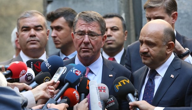 US Defense Secretary Ash Carter, accompanied by Turkey's Defense Minister Fikri Isik (R), talks to media as he visits Turkish Parliament which was partly damaged during the coup attempt, in Ankara, Turkey