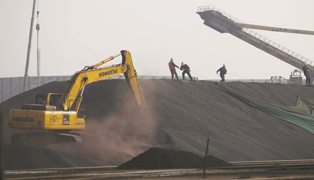 Labourers work on a pile of iron ore at a steel factory in China. Benchmark iron ore has surged more than a third in 2016, to snap three years of declines, after China added stimulus to counter slower growth, boosting steel production as the property sector recovered.