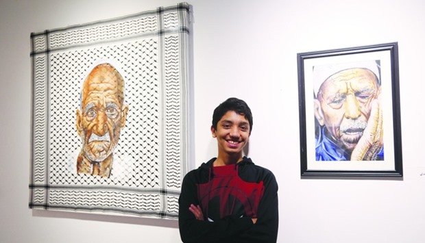 15-year old Palestinian artist, Mohamed Qraiqea, with two of his paintings on display at Katara. PICTURE: Jayan Orma