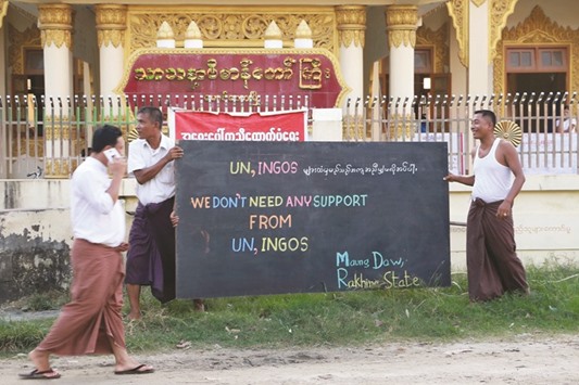 Buddhist Rakhine men set up a sign reading, u2018We donu2019t need any support from UN, INGOs u2013 Maungdaw Rakhine stateu2019 outside a monastery in that has become a makeshift refugee camp in Maungdaw. Food aid for more than 80,000 people in parts of northwest Myanmar has been suspended because of a military clampdown in the area, the World Food Programme said this week.