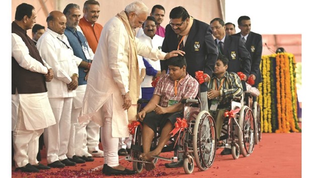 Prime Minister Narendra Modi speaks to a disabled person after distributing artificial limbs, tri-cycles and other assisting devices to over 10,000 u2018divyangsu2019 or differently-abled persons in Vadodara yesterday.