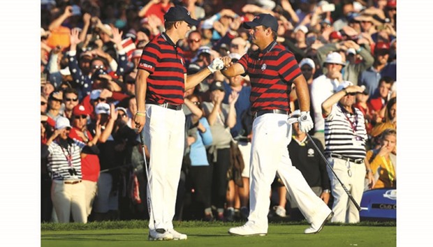 Jordan Spieth and Patrick Reed of the United States react Saturday on the 16th green during afternoon fourball matches of the 2016 Ryder Cup at Hazeltine National Golf Club in Chaska, Minnesota.