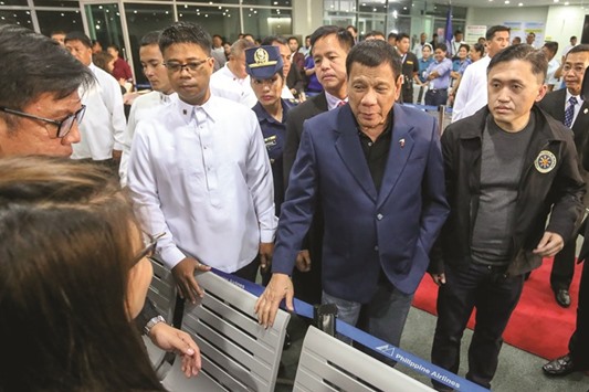 President Rodrigo Duterte walks through the terminal at the Davao International Airport after arriving back from a state visit to Brunei and China yesterday.