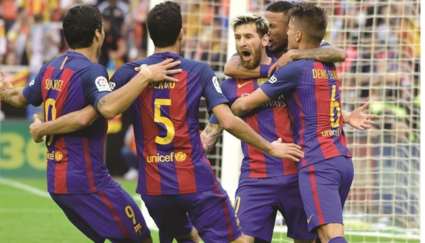 Barcelonau2019s Argentinian forward Lionel Messi (C) celebrates with teammates after scoring during the Spanish league match against Valencia yesterday.