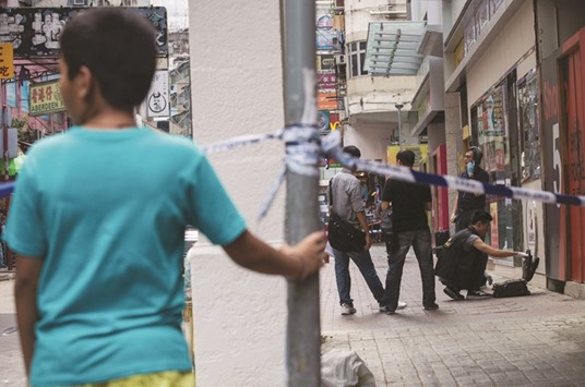 Officers process a crime scene where police opened fire on men fighting in the Yau Ma Tei district of Hong Kong.