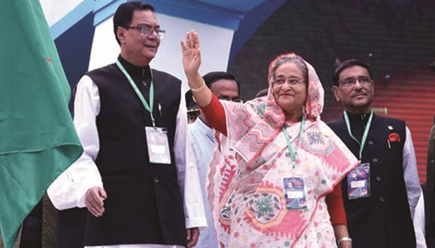 Prime Minister Sheikh Hasina waving at delegates at the 20th council of the ruling Awami League as party secretary general Syed Ashraful Islam, and joint secretary general Obaildul Quader look on in Dhaka yesterday.