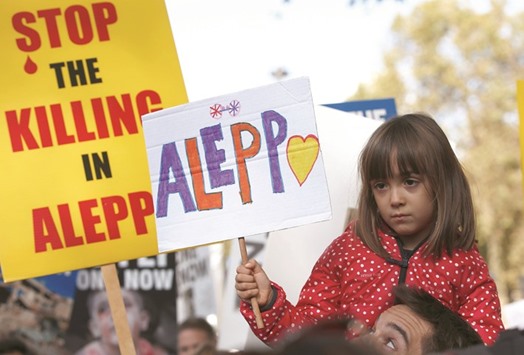 A child holds a placard during a demonstration urging the British government to intervene in the bombing of Aleppo, outside Downing Street, London, yesterday.