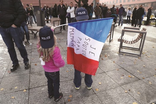 Children hold a flag reading u2018I support mum and dadu2019 as French police officers gather yesterday in Evry in the southern suburbs of Paris during a protest against mounting attacks on officers.