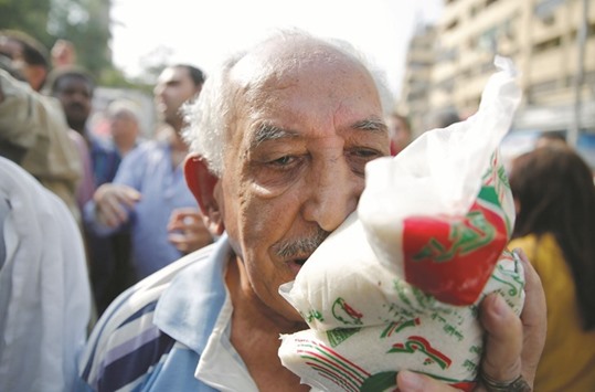 A man carries subsidised sugar after buying it from a government truck during a sugar shortage in retail stores across the country in Cairo on Friday. After six years of unrest, terrorist attacks and a collapse in the tourism industry, Egyptu2019s economy has been crippled by spiralling inflation and a shortage of foreign currency, making it tougher to import basic commodities.