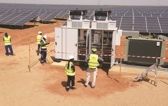 Technicians operate electrical cabinets during the opening ceremony of a new photovoltaic energy production site in Bokhol on Saturday.