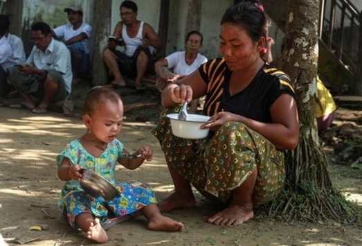 An ethnic Rakhine woman who fled the violence in Maungdaw feeds her daughter at a monastery being used as a temporary camp in Sittwe, Myanmar.