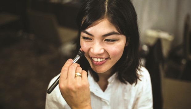 A stylist working on the make-up for Rina Fukushi before a show by Japanese designer Tae Ashida in Tokyo.
