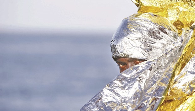 This handout picture taken and released by the Italian Red Cross on Saturday shows a migrant wrapped in a survival foil blanket after landing in Vibo Marina, southern Italy, following a rescue operation in the Mediterranean Sea.