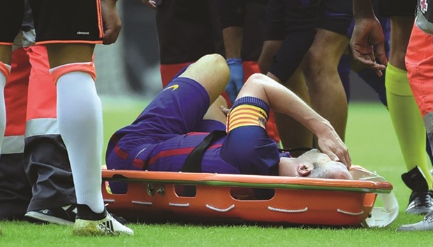 Barcelonau2019s Andres Iniesta lies on a stretcher after being injured during the match against Valencia on Saturday. (AFP)