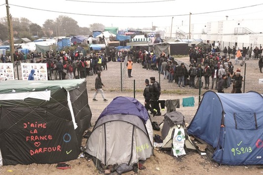Migrants queuing outside a hangar where they were sorted into groups and put on buses for shelters across France, as part of the full evacuation of the Calais u2018Jungleu2019 camp.