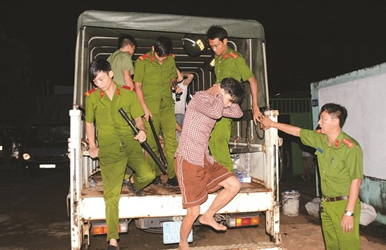 Authorities lead drug addicts from the back of a truck after they were rearrested following a break out from a compulsory drug rehabilitation centre in the southern Vietnamese province of Dong Nai early yesterday.