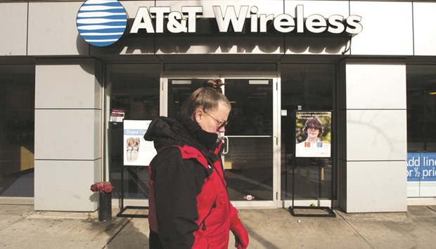 A pedestrian walks past an AT&T Wireless store in New York. AT&T said late on Saturday the Time Warner deal would need approval of the US Justice Department and the companies were determining which Time Warner US Federal Communications Commission licences, if any, would transfer to AT&T as part of the deal. Any such transfers would require FCC approval.