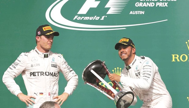 Mercedesu2019 Lewis Hamilton (right) celebrates with the trophy as teammate Nico Rosberg, who finished second, looks on after the US Grand Prix in Austin, Texas on Sunday. (Reuters)