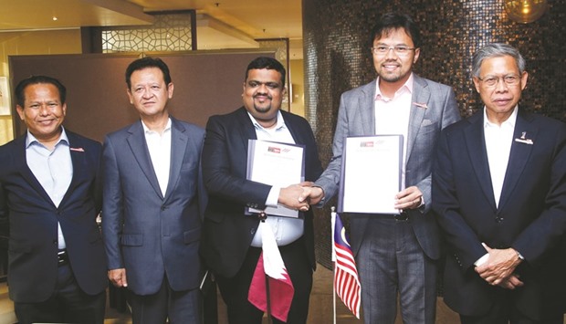 Malaysian Minister of International Trade and Industry Mustapa Mohamed (right) joins officials of Masskar Hypermarket and Infinity Channel, who signed a memorandum of understanding for the distribution of u201cfast sellingu201d Malaysian products in the Qatar market. Also present at the MoU signing was Malaysian ambassador Ahmad Jazri Mohamed Johar. PICTURE: Jayaram