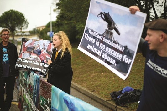 Protesters hold up a placard reading u2018Itu2019s time to take whale meat off the menuu2019 as they demonstrate during the 66th International Whaling Commission (IWC) meeting in Portoroz.
