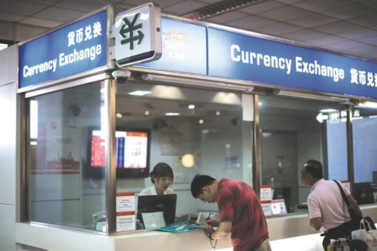 A man changes foreign currency into yuan at an exchange office in Shanghai airport. The offshore yuan traded near a record low as Chinese policy makers signalled they are willing to allow greater currency flexibility amid a slump in exports and an advance in the dollar.