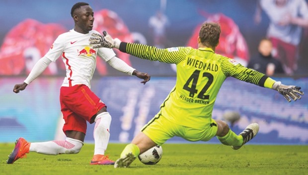 Leipzigu2019s Guinean midfielder Naby Keita (L) scores the first goal past Bremenu2019s goalkeeper Felix Wiedwald during the German first division Bundesliga match in Leipzig. (AFP)