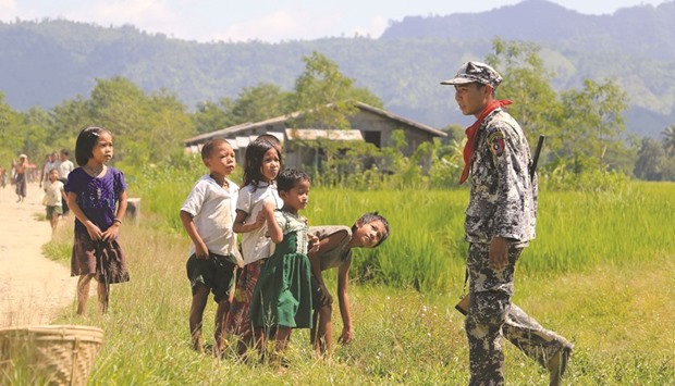 A recent photo shows Myo ethnic children look at a Myanmar border police in LaungDon, located in Rakhine State as security operation continues following the October 9 attacks by armed militants.