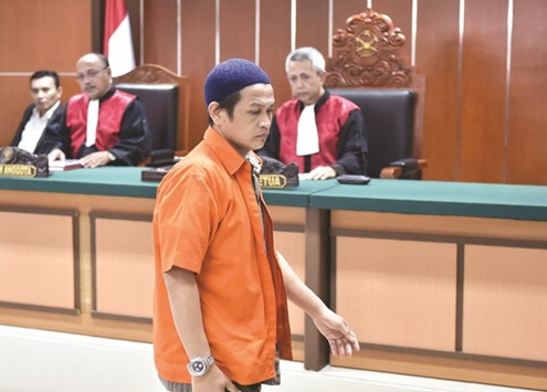 Ali Makhmudin (blue cap) leaves the court room after the judgesu2019 verdict in Jakarta yesterday.