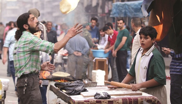 A man makes bread in the rebel held besieged Aleppo, Syria yesterday.