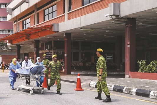Medical workers evacuate a patient after a fire engulfed the Sultanah Aminah Hospital, a day after a blaze at the facility killed six patients in Johor Bahru, southern Malaysia, yesterday.