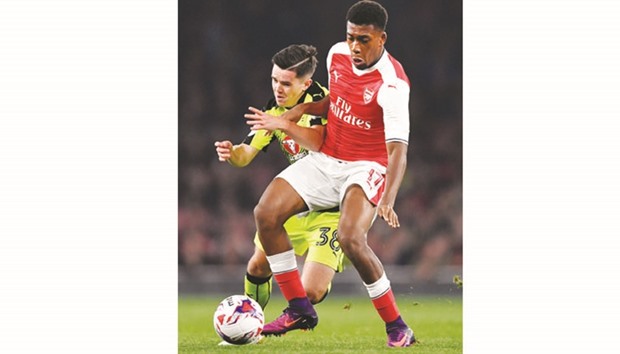 Arsenalu2019s Alex Iwobi (right) vies for the ball with Readingu2019s Liam Kelly during the League Cup fourth round match on Tuesday night. (Reuters)