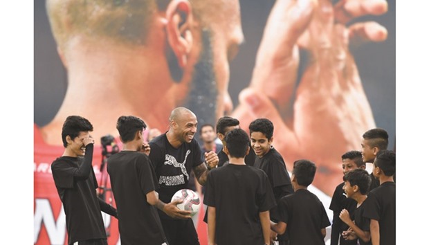 Former French and Arsenal striker Thierry Henry (centre) interacts with children during a promotional event in Mumbai yesterday. (AFP)