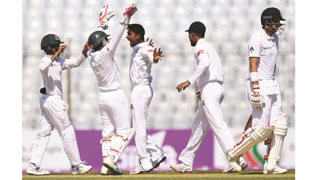 In this October 20, 2016, picture, Bangladeshu2019s Mehedi Hasan (centre) celebrates the wicket of Englandu2019s Joe Root (right) on Day One of the first Test in Chittagong. Englandu2019s top four batsmen, including Root, Alastair Cook, Ben Duckett and Gary Ballance, have managed a combined total of only 96 runs in both innings. (AFP)