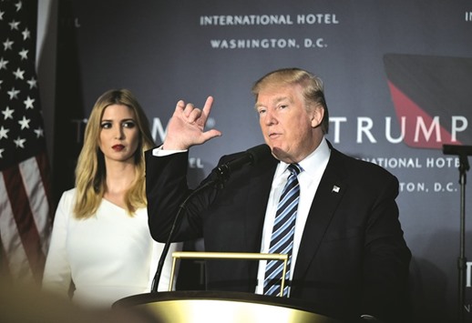 Donald Trump speaks during the grand opening of the Trump International Hotel as his daughter Ivanka looks on in Washington, DC yesterday.