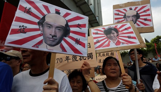Pro-China protesters carry printouts depicting legislator-elects Baggio Leung (L, R) and Yau Wai-ching (C) as traitors during a demonstration outside the Legislative Council in Hong Kong