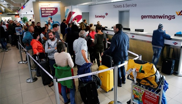 People line up in front of a counter of Lufthansa's budget airlines Eurowings and Germanwings during a 24-hour strike