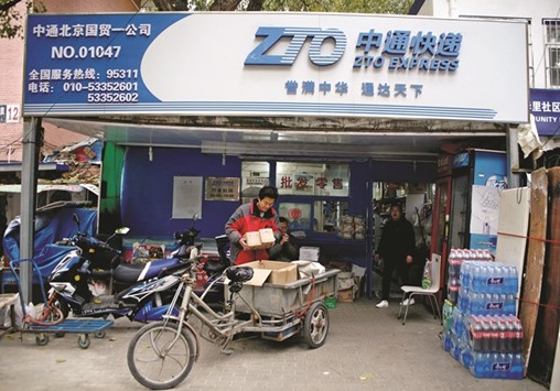 A deliveryman holds parcels at a branch of ZTO Express in Beijing. The Chinese package delivery company raised $1.4bn in the biggest US initial public offering of the year on Wednesday as its backers cashed in on Chinau2019s booming online-shopping industry, a source familiar with the deal said.