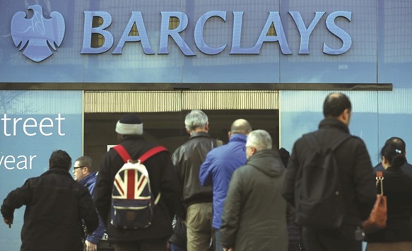 Customers queue outside a branch of Barclays Bank in Manchester northern England. Shares in the bank rallied to the top of the FTSE 100 risersu2019 board, as investors shrugged off rising mis-selling costs and flat net profits to focus on news of a jump in underlying pretax earnings.