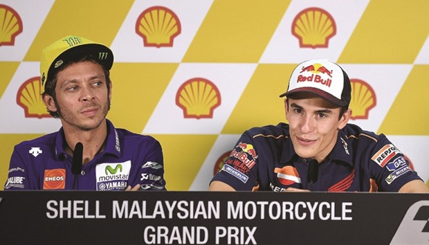 Movistar Yamaha rider Valentino Rossi (left) looks on as Repsol Honda rider Marc Marquez addresses a press conference ahead of the Malaysian Grand Prix at Sepang International Circuit yesterday. (AFP)