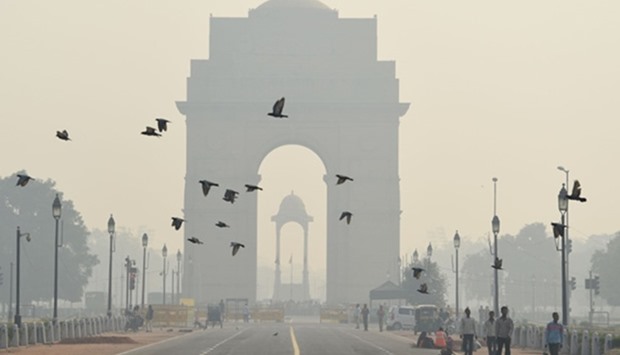 Pedestrians walk near the India Gate monument amid heavy smog in New Delhi
