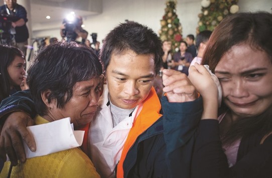 Filipino fisherman Antonio Libres (centre), who was held hostage for nearly five years by Somali pirates, hugs his relatives after arriving at Manila International Airport yesterday.