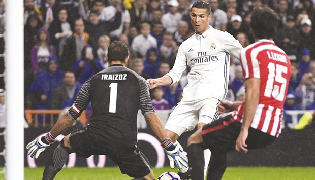 File picture of Real Madridu2019s Portuguese forward Cristiano Ronaldo (C) vying for the ball with Athletic Bilbaou2019s goalkeeper Gorka Iraizoz (L) during their Spanish league football match at the Santiago Bernabeu stadium in Madrid on October 23.